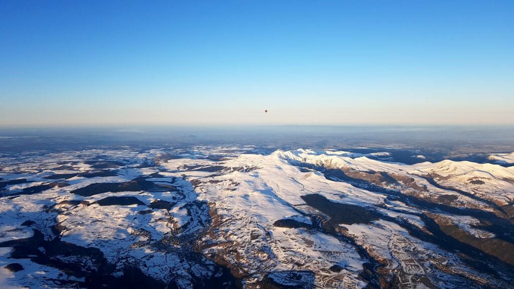 Massif du Sancy enneigé avec montgolfière