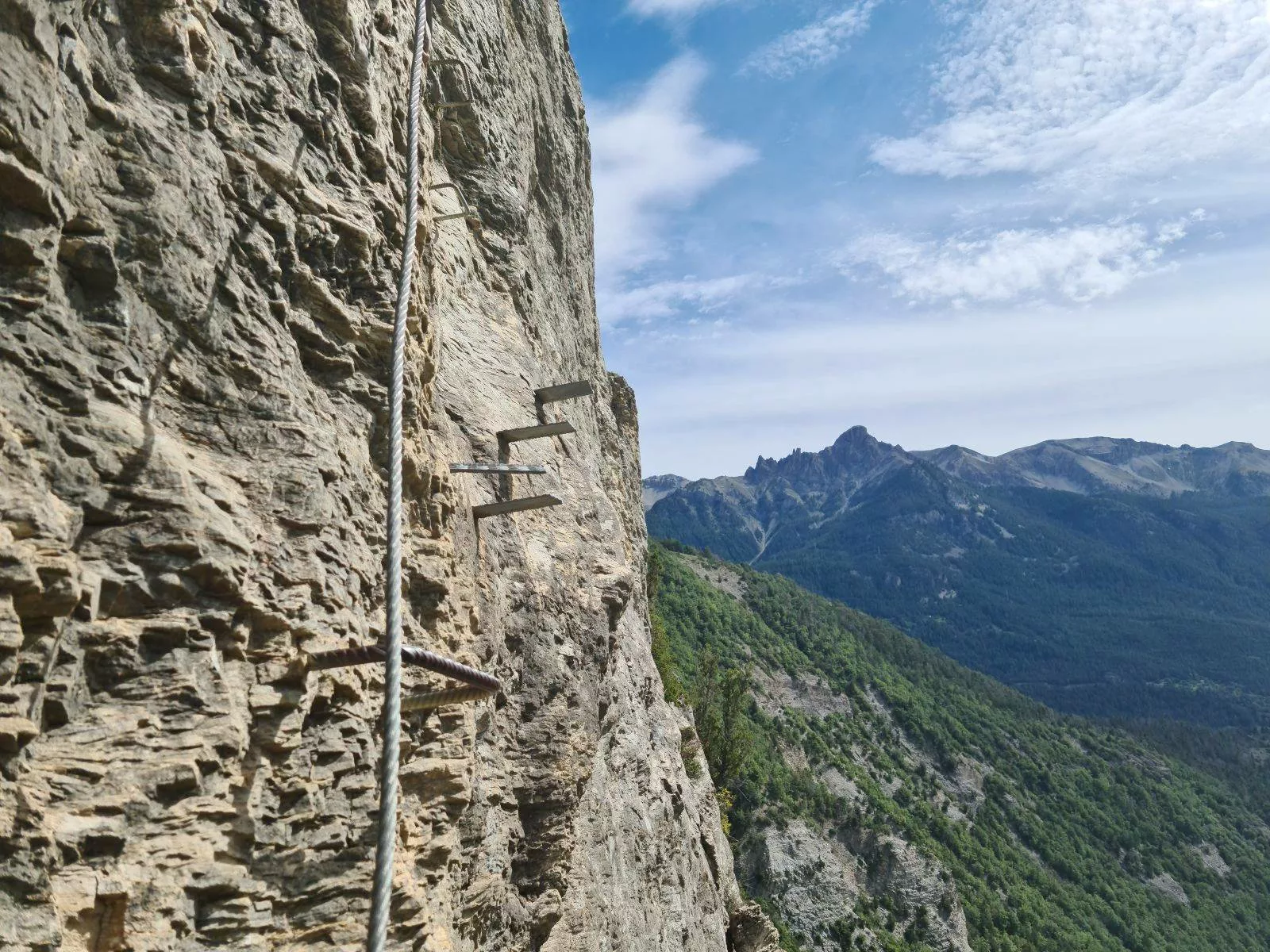 ligne de vie de via ferrata et marche métallique scellée dans la paroi
